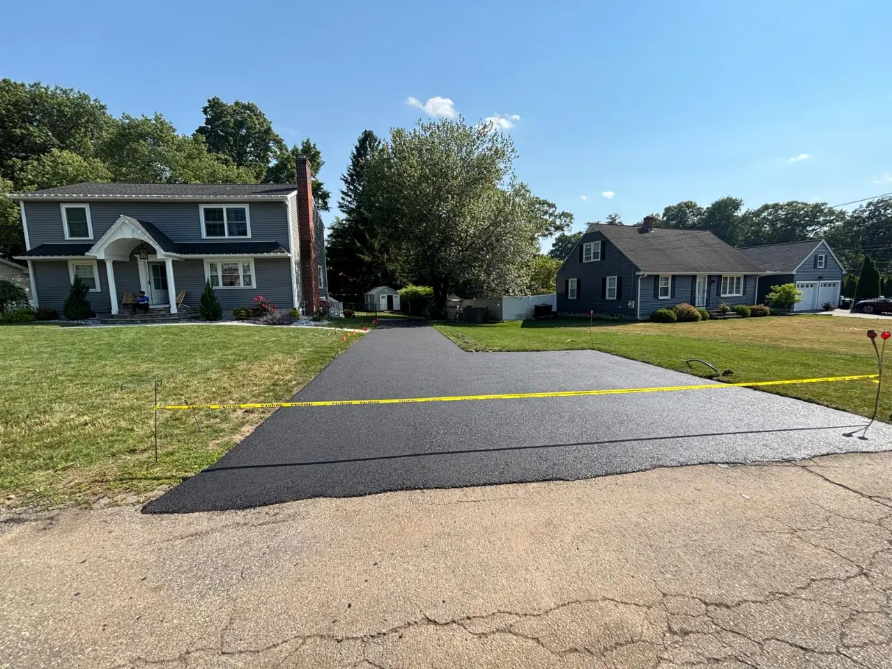 Asphalt paving crew installing hot mix on a Massachusetts driveway